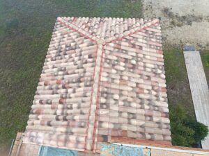 Vue aérienne d'une toiture en croupe en tuiles canal nuancées avec faîtage et arêtiers scellés